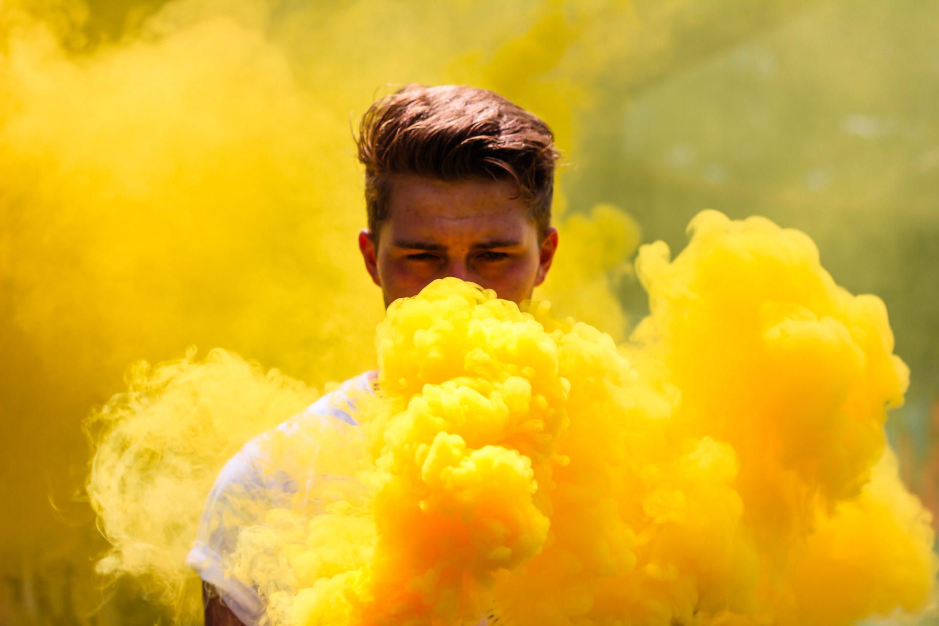 Man being hidden behind a plume of yellow smoke from a flare