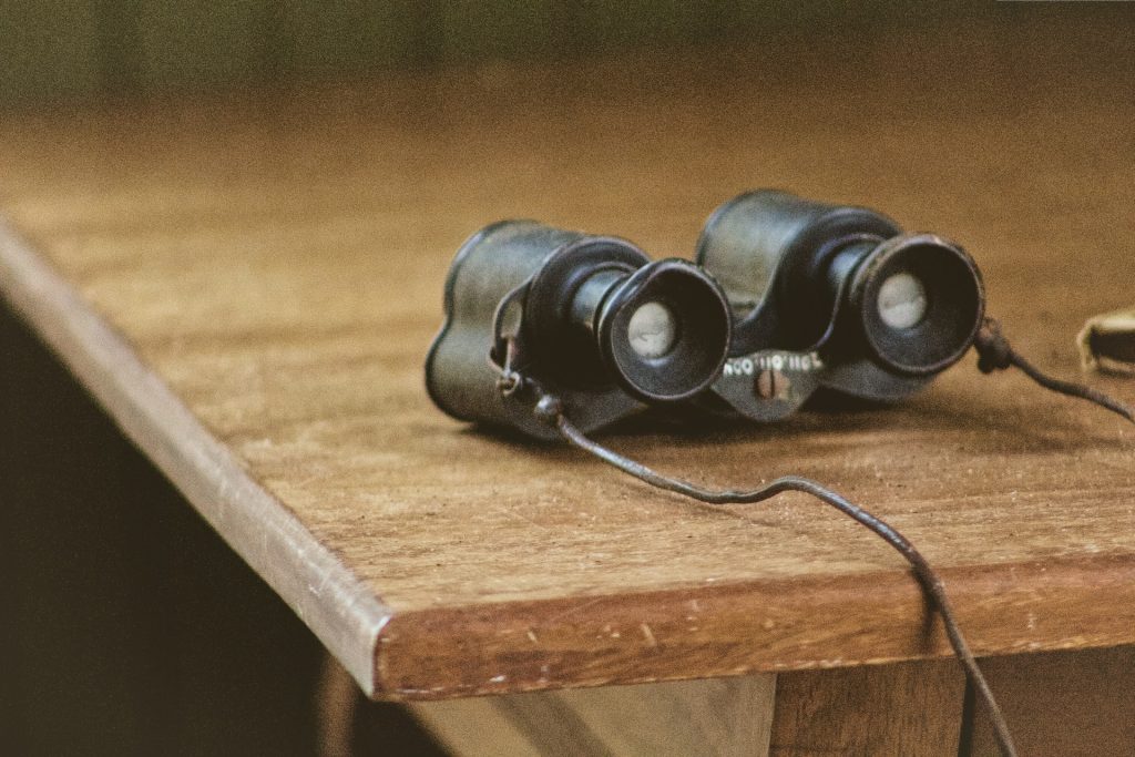 Binoculars on a on a wooden table